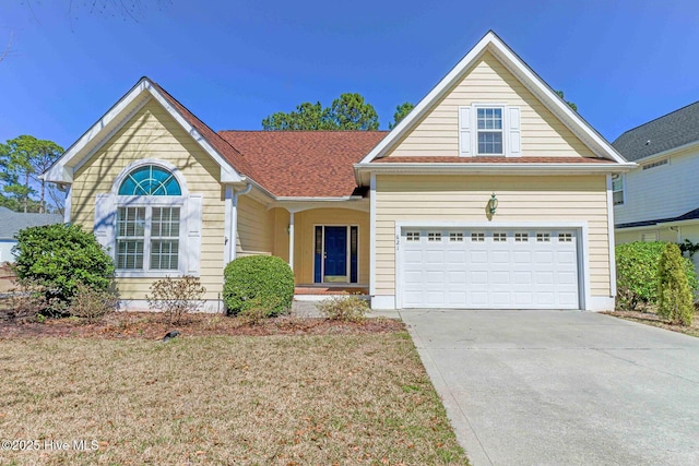 view of front of home with a front lawn, a garage, and driveway