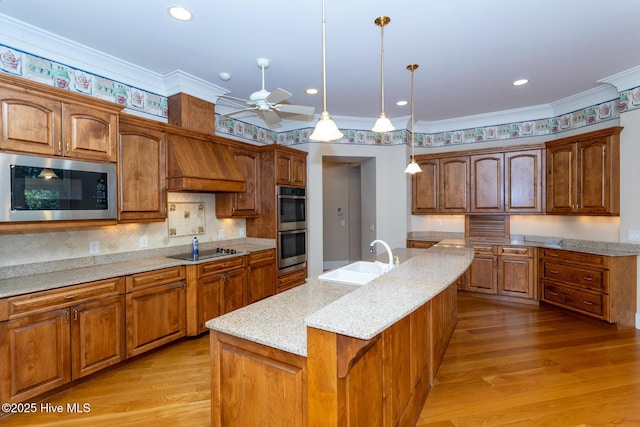 kitchen featuring custom exhaust hood, light wood-style flooring, built in microwave, a sink, and black electric cooktop