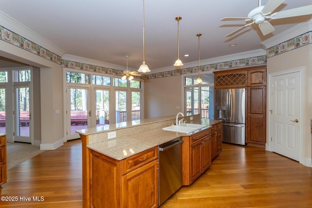 kitchen with ornamental molding, appliances with stainless steel finishes, light wood-style flooring, and a sink