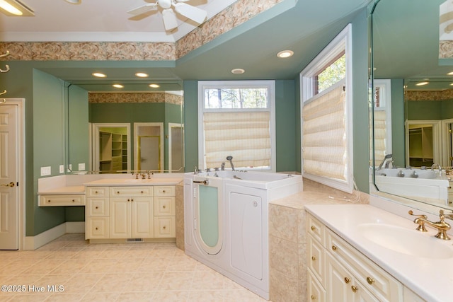 bathroom featuring a bath, tile patterned floors, two vanities, and a sink