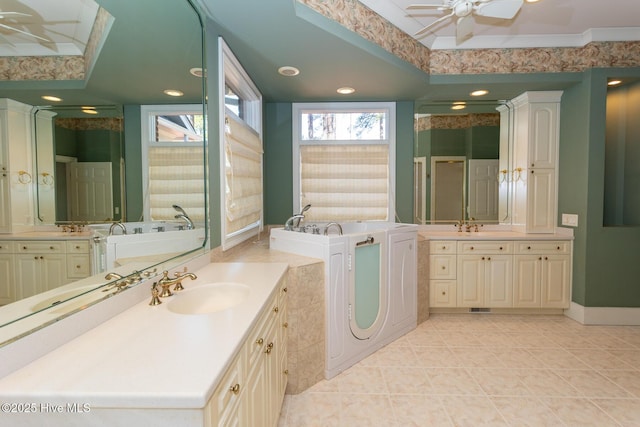 bathroom featuring tile patterned flooring, a ceiling fan, a tray ceiling, and a sink