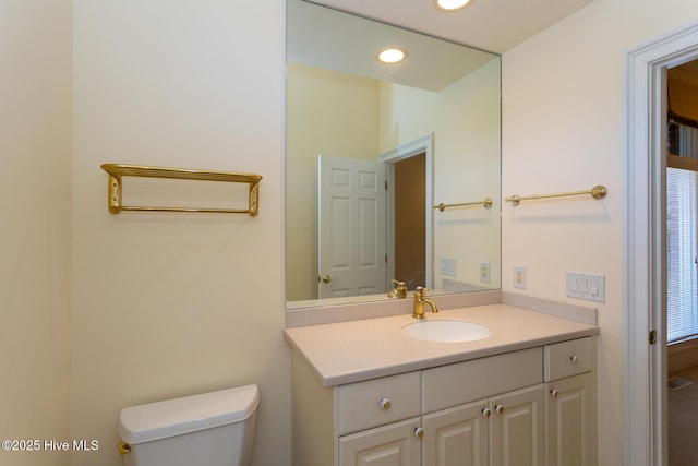 bathroom featuring recessed lighting, toilet, and vanity