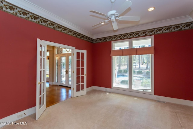 empty room with carpet, crown molding, french doors, and a wealth of natural light