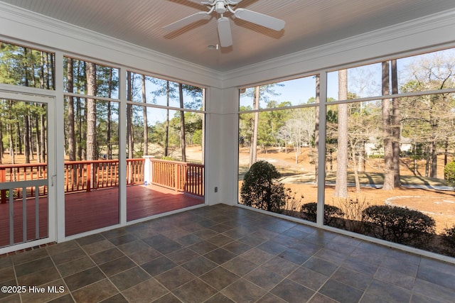 unfurnished sunroom featuring a ceiling fan