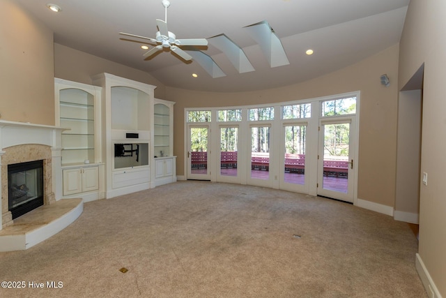 unfurnished living room with a high end fireplace, carpet flooring, recessed lighting, and vaulted ceiling