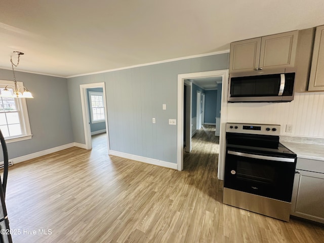 kitchen with gray cabinets, light countertops, appliances with stainless steel finishes, crown molding, and light wood-type flooring