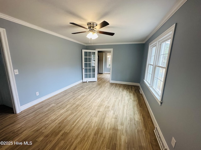 empty room with ceiling fan, baseboards, wood finished floors, and crown molding