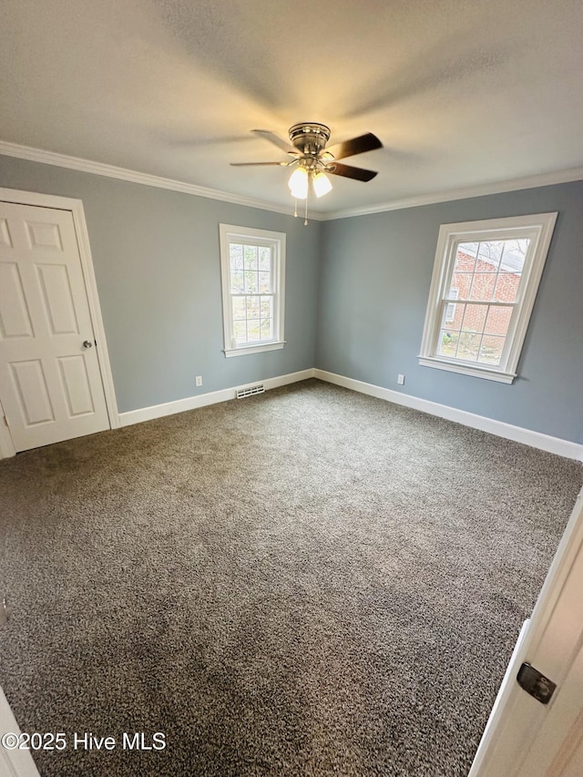 unfurnished room with visible vents, ornamental molding, baseboards, and carpet floors