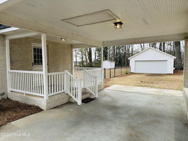 view of patio / terrace featuring an outbuilding, a porch, fence, and a garage