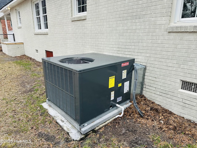 exterior details with brick siding, crawl space, and central AC