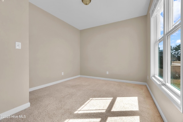 carpeted empty room featuring baseboards