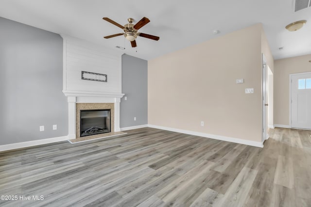 unfurnished living room featuring a fireplace, visible vents, and baseboards