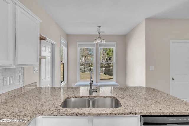 kitchen with a sink, dishwashing machine, and white cabinets