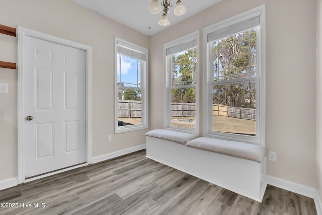 living area featuring baseboards, plenty of natural light, and wood finished floors