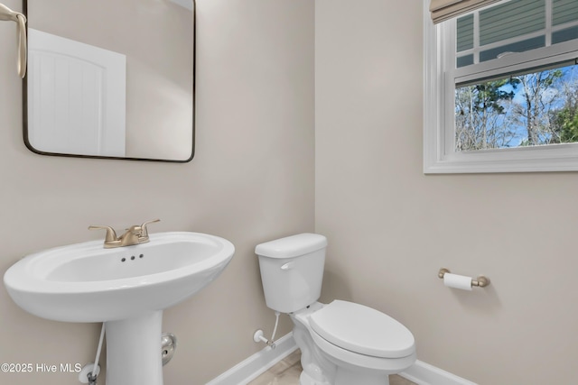 bathroom with a sink, baseboards, and toilet