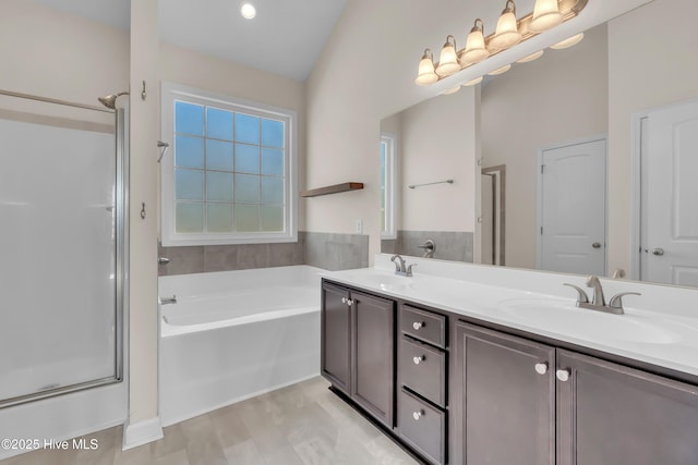 full bathroom with a sink, a stall shower, double vanity, and a bath