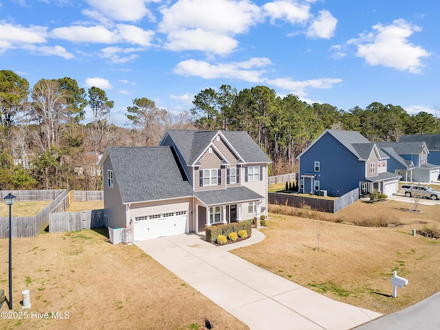 traditional-style home with a front yard, fence, a garage, and driveway