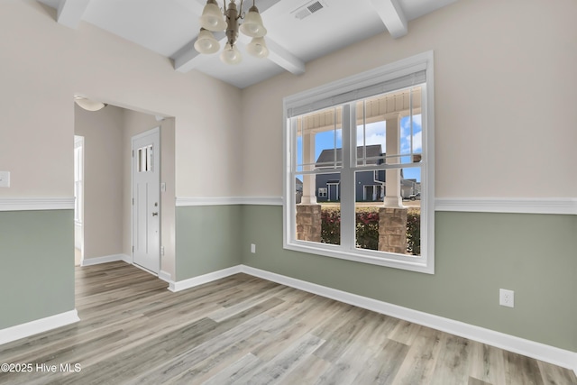 unfurnished room with visible vents, beam ceiling, and baseboards