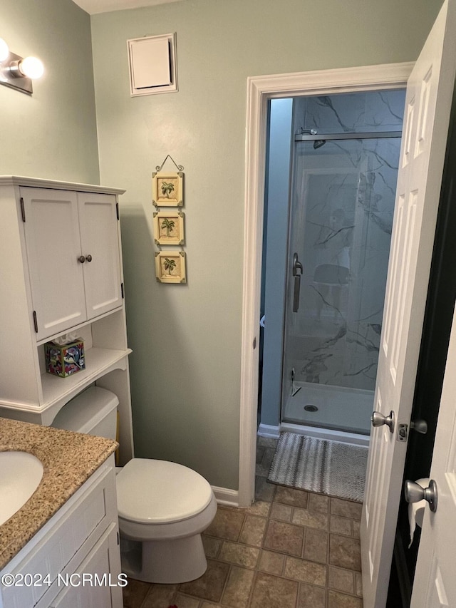 full bathroom featuring vanity, toilet, baseboards, and a marble finish shower