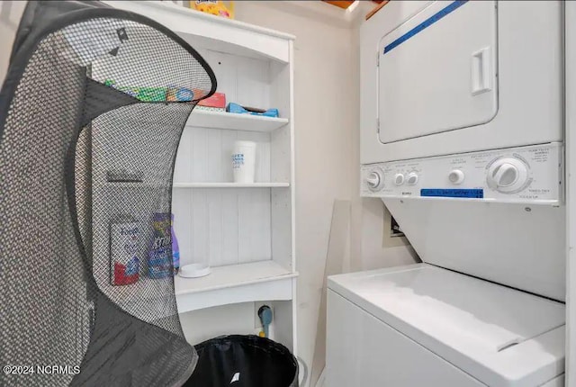 clothes washing area featuring stacked washer / dryer and laundry area