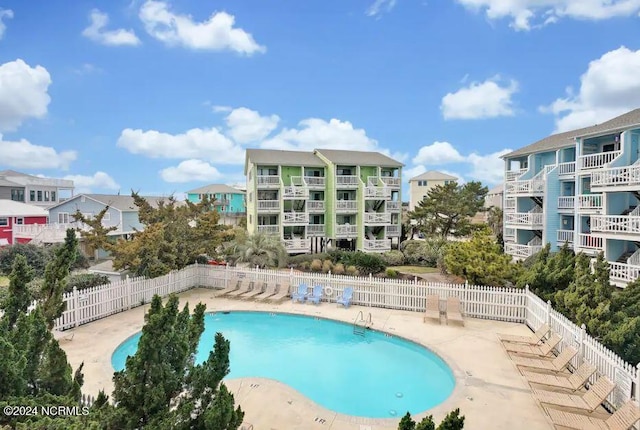 community pool featuring a patio and fence