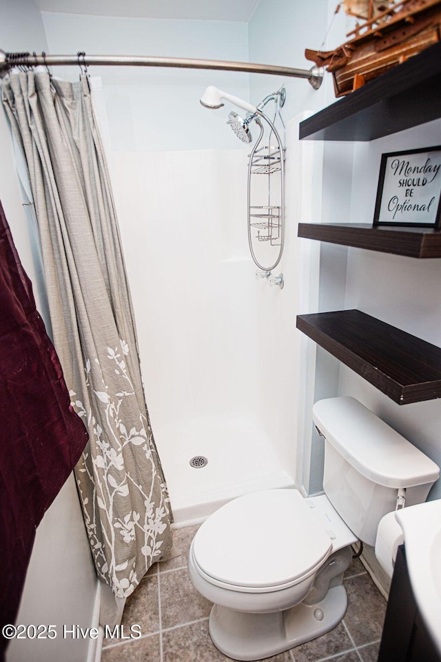 full bath with tile patterned flooring, a shower stall, and toilet