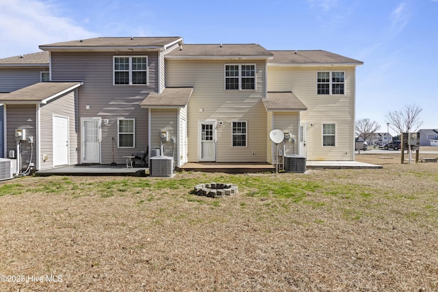 back of house featuring a yard, a fire pit, and a deck