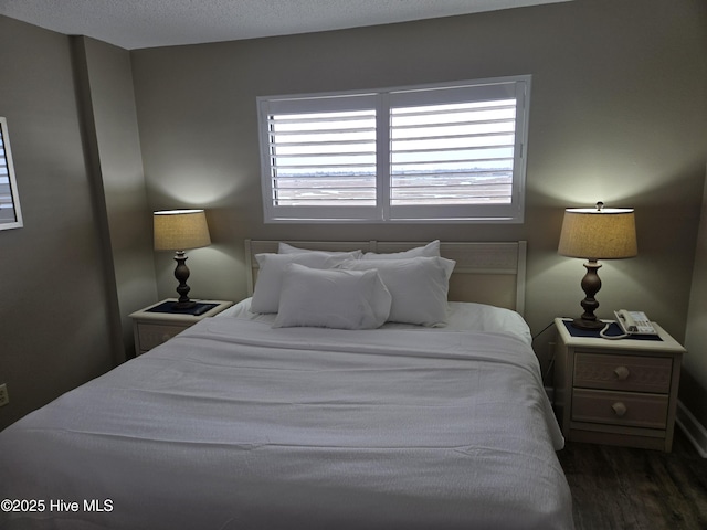 bedroom with dark wood-type flooring and a textured ceiling