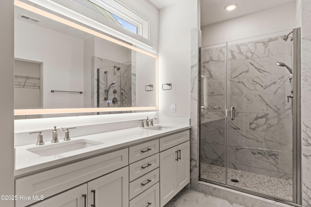 full bath with a shower stall, visible vents, marble finish floor, and a sink