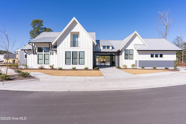 modern farmhouse style home with an attached carport, board and batten siding, and a standing seam roof