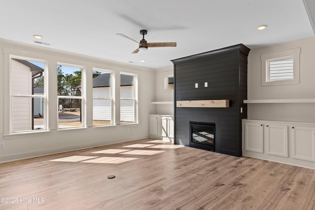 unfurnished living room featuring a ceiling fan, baseboards, recessed lighting, a fireplace, and light wood-style floors