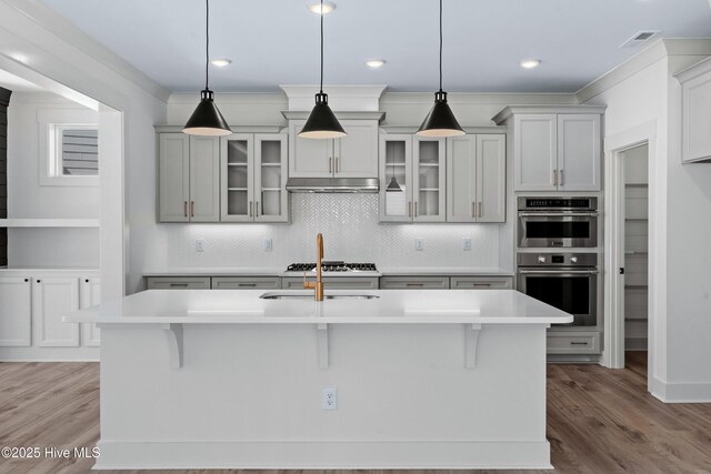 unfurnished dining area featuring visible vents, baseboards, a notable chandelier, and wood finished floors