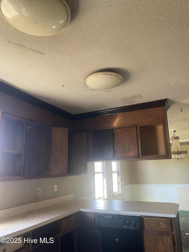 kitchen featuring dishwasher, light countertops, and a textured ceiling