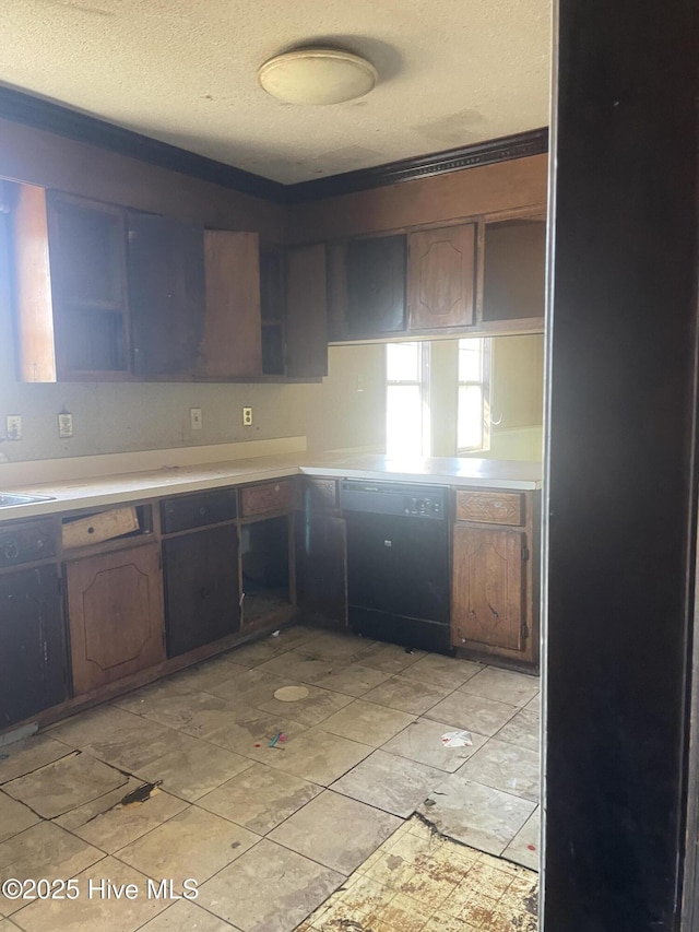 kitchen with dishwasher, light countertops, a sink, and a textured ceiling