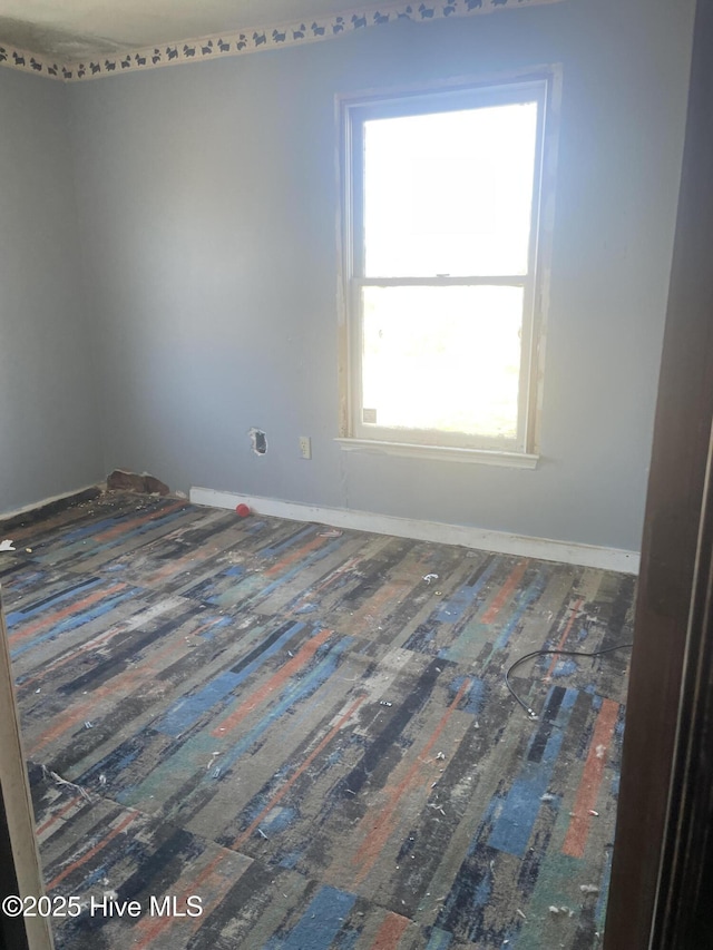 empty room featuring baseboards and wood finished floors