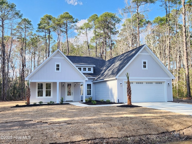 modern farmhouse featuring a porch, concrete driveway, a garage, and a shingled roof