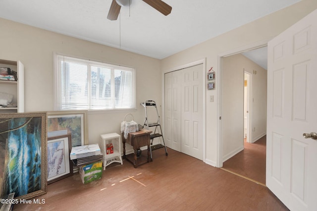 interior space featuring a ceiling fan, wood finished floors, and baseboards