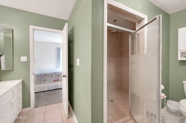 bathroom featuring toilet, ensuite bathroom, a shower stall, tile patterned flooring, and vanity