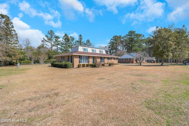 view of front of property with brick siding and a front lawn