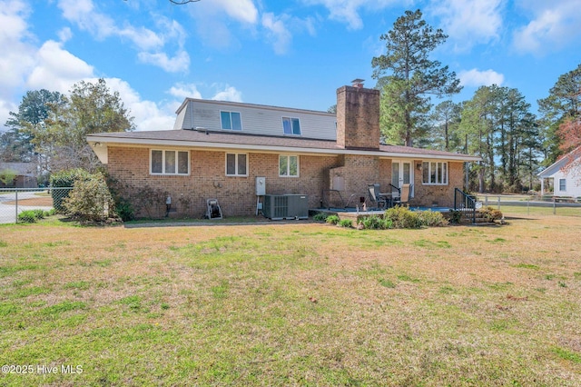 rear view of property featuring cooling unit, a chimney, a yard, and fence