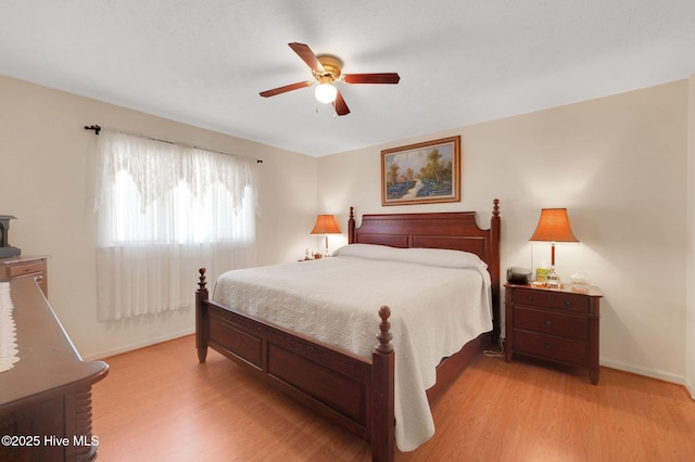 bedroom with a ceiling fan, baseboards, and light wood finished floors