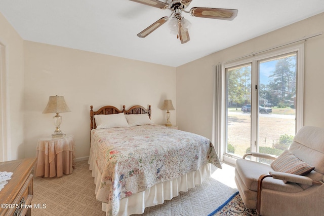 bedroom featuring access to exterior, multiple windows, a ceiling fan, and light carpet