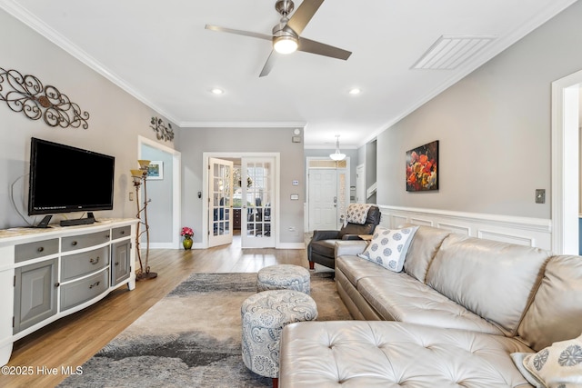 living area with visible vents, ornamental molding, recessed lighting, wood finished floors, and a ceiling fan