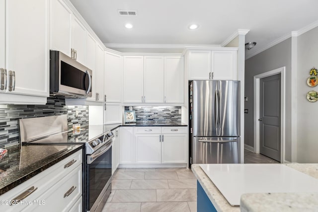 kitchen with visible vents, backsplash, crown molding, stainless steel appliances, and white cabinetry