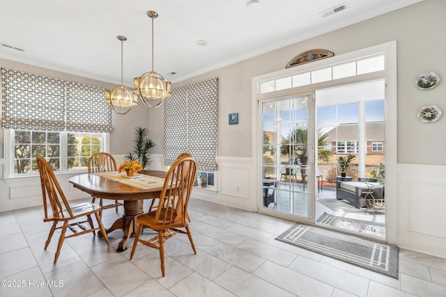 dining room with visible vents, a wainscoted wall, a chandelier, and crown molding