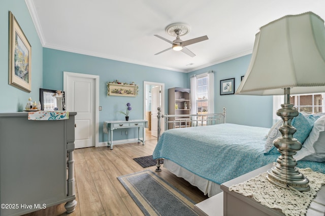 bedroom with ceiling fan, light wood-type flooring, crown molding, and baseboards