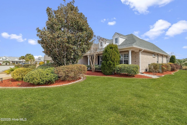 exterior space featuring a lawn, brick siding, and a shingled roof