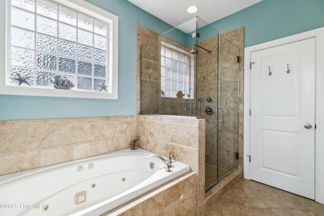 full bath with tile patterned floors, a tub with jets, and a stall shower