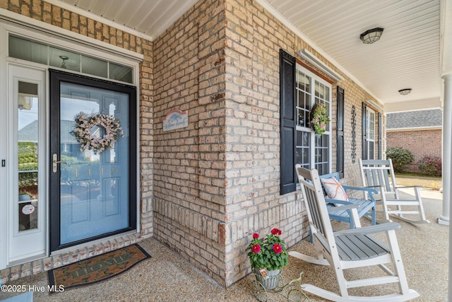 property entrance featuring brick siding and covered porch