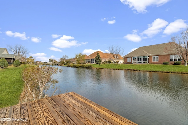 view of dock featuring a yard and a water view